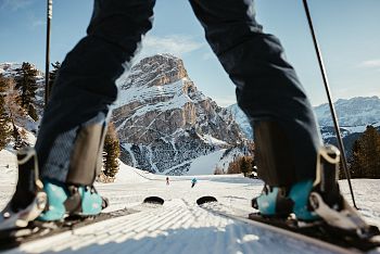 Ski Fahrerin auf unberührter Piste mit Sicht auf den  Sassongher
